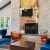 a spacious room with a fireplace and blue chairs