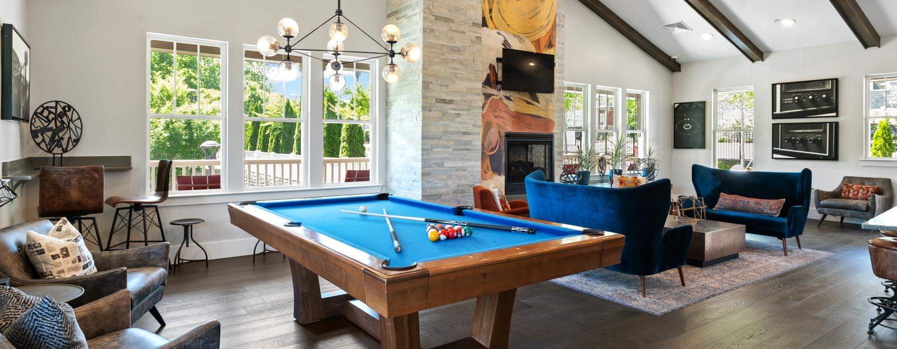 a room with a pool table and chairs