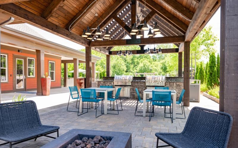 a patio with chairs and a fire pit